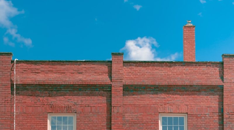 a red brick building with a street sign in front of it